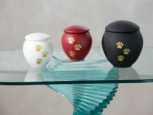 Drei Tierurnen in weiß, rot und schwarz